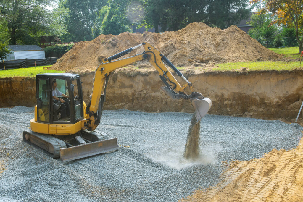 Excavator filling in holes with gravel