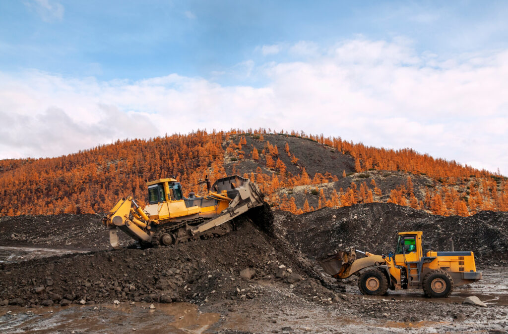 Wheel loaders and bulldozers in operation in an industrial mountainous area