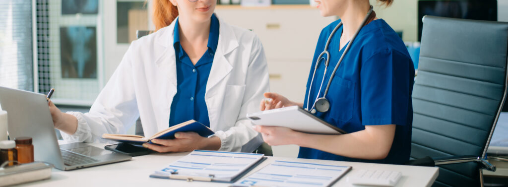 Doctor and nurse team using laptop to review medical results