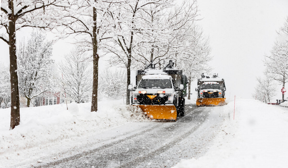 snow plowing machine in suburban neighborhood during northeastern storm
