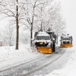 snow plowing machine in suburban neighborhood during northeastern storm