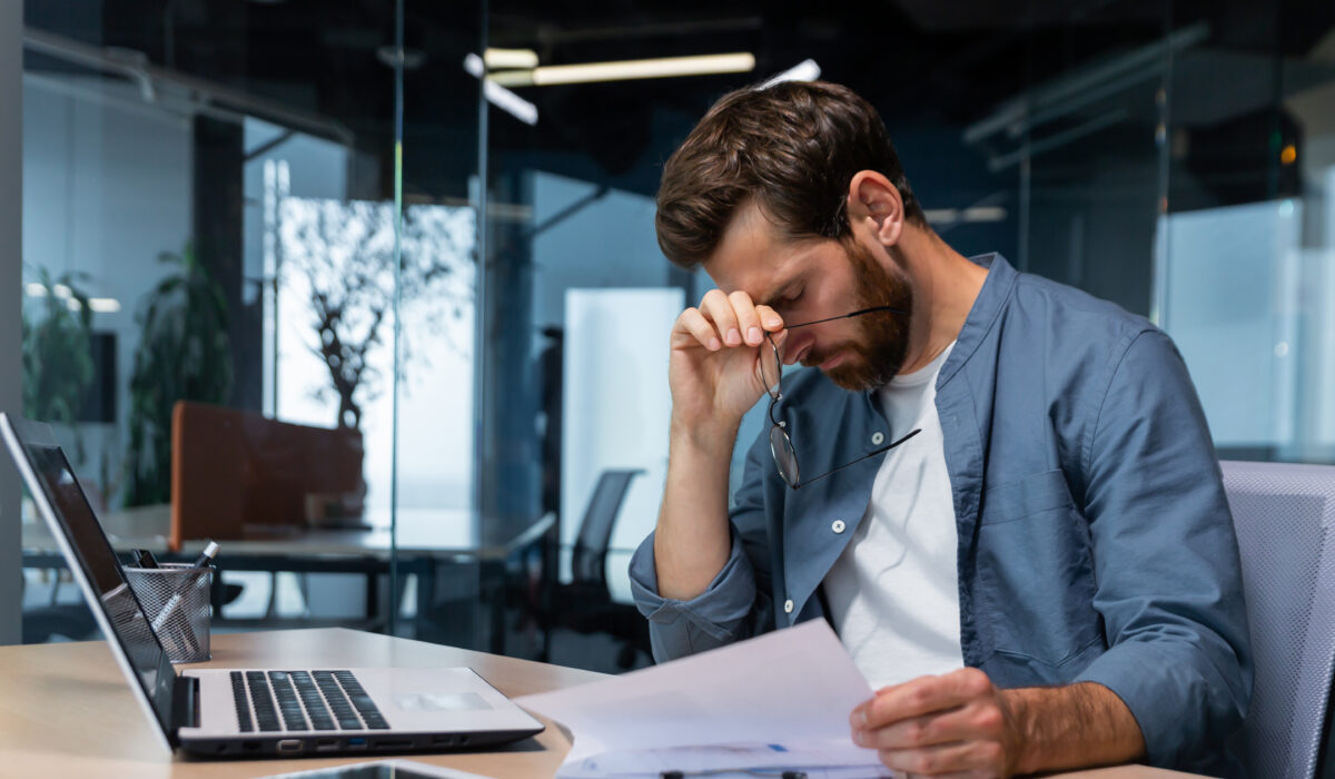 Upset businessman behind paper work