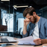 Upset businessman behind paper work