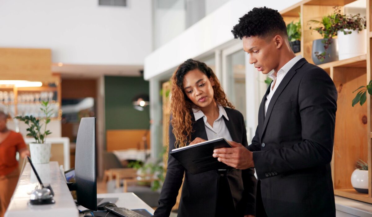 Reception, employees and tablet with teamwork, hotel and accommodation with cooperation.