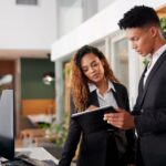 Reception, employees and tablet with teamwork, hotel and accommodation with cooperation.