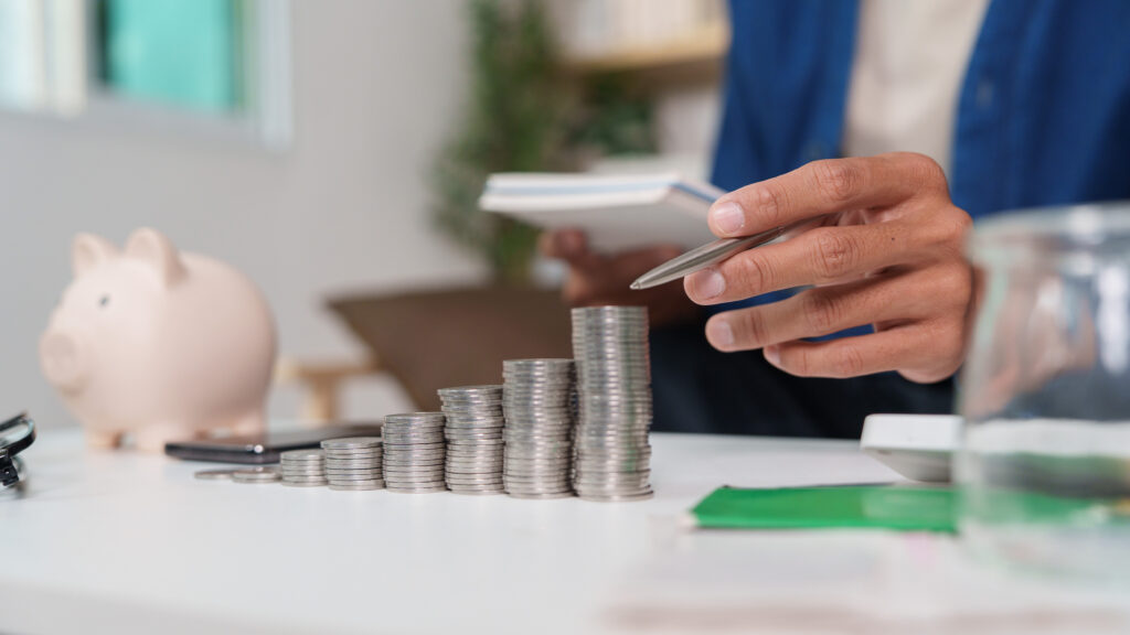 Man planning finances with stacks of coins in front of him