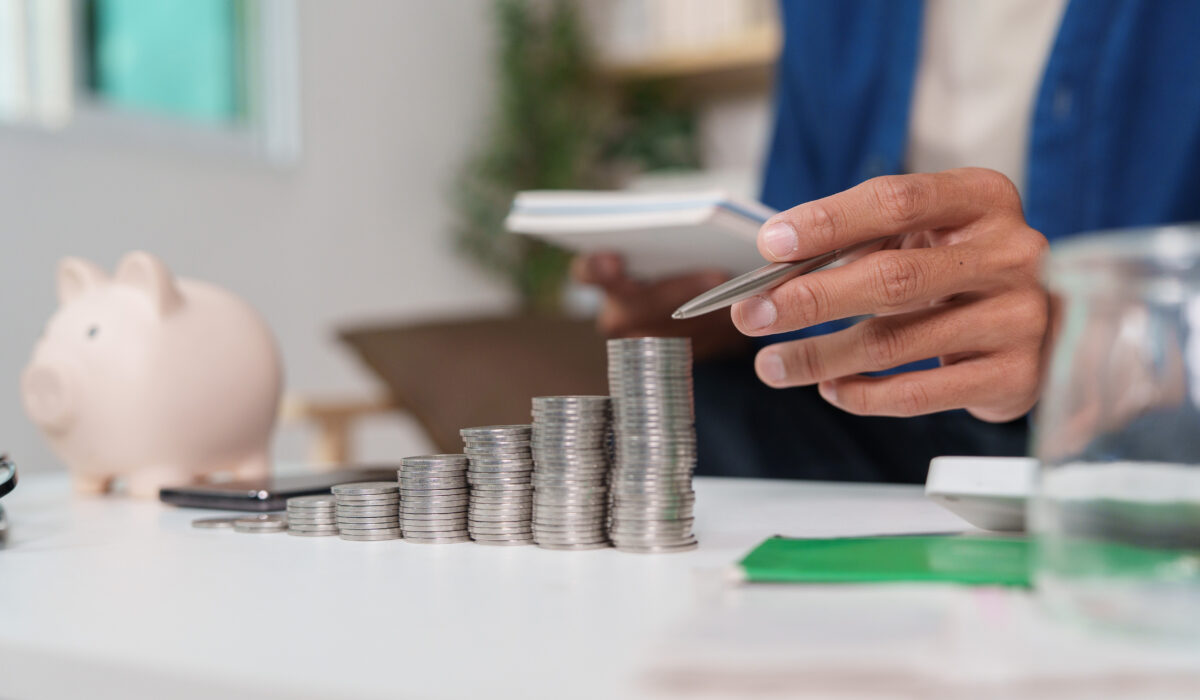 Man planning finances with stacks of coins in front of him