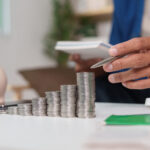 Man planning finances with stacks of coins in front of him