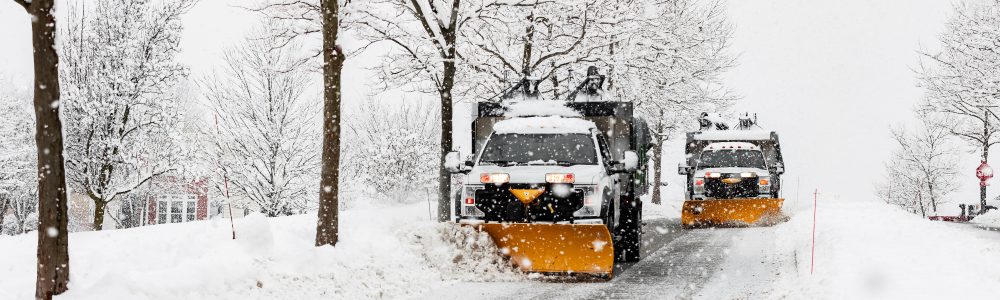 snow plowing machine in suburban neighborhood during northeaster